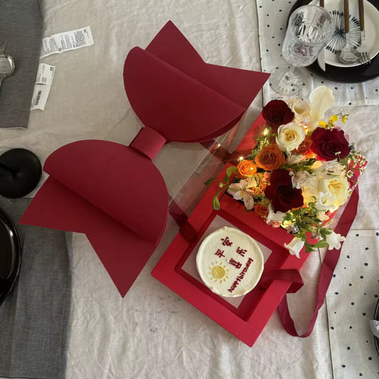 Luxury clear gift boxes with large red bows, elegant packaging for flowers or gifts.