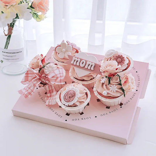 Clear cupcake box with pink insert forming a heart shape, holds six cupcakes.
