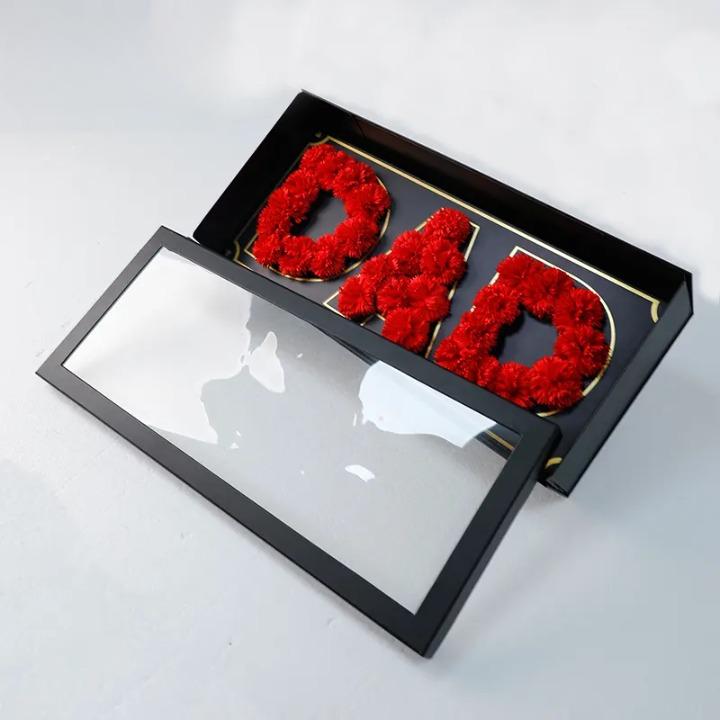 Black DAD packaging box with gold accents and transparent lid.