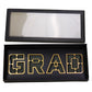 Foldable black GRAD box with clear lid and foam liner for graduation gifts.