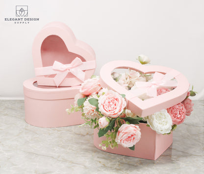 Pink Heart Shaped Box with Ribbon and Clear Lid displaying a flower arrangement